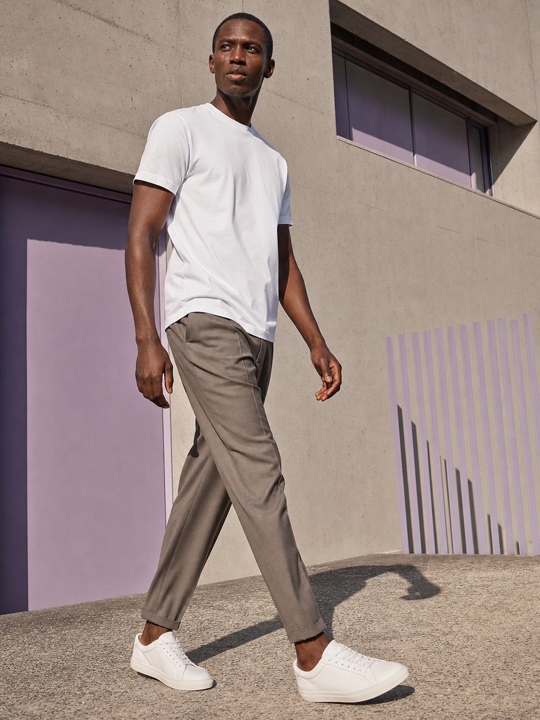 African male model wearing the white T-shirt in a city lifestyle scene