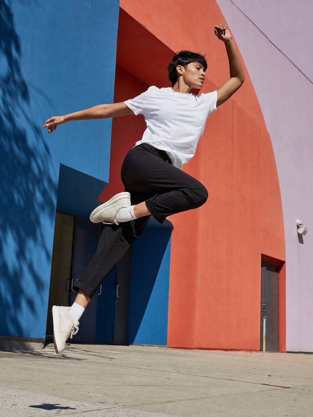 Model wearing the white T-shirt in a colorful dynamic lifestyle scene